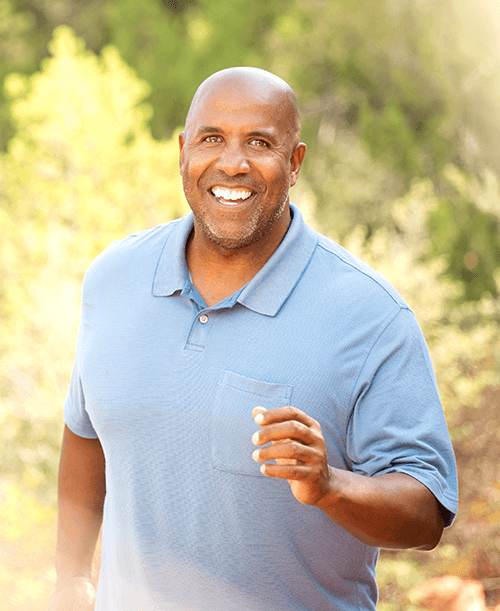 Guy running happily outside.